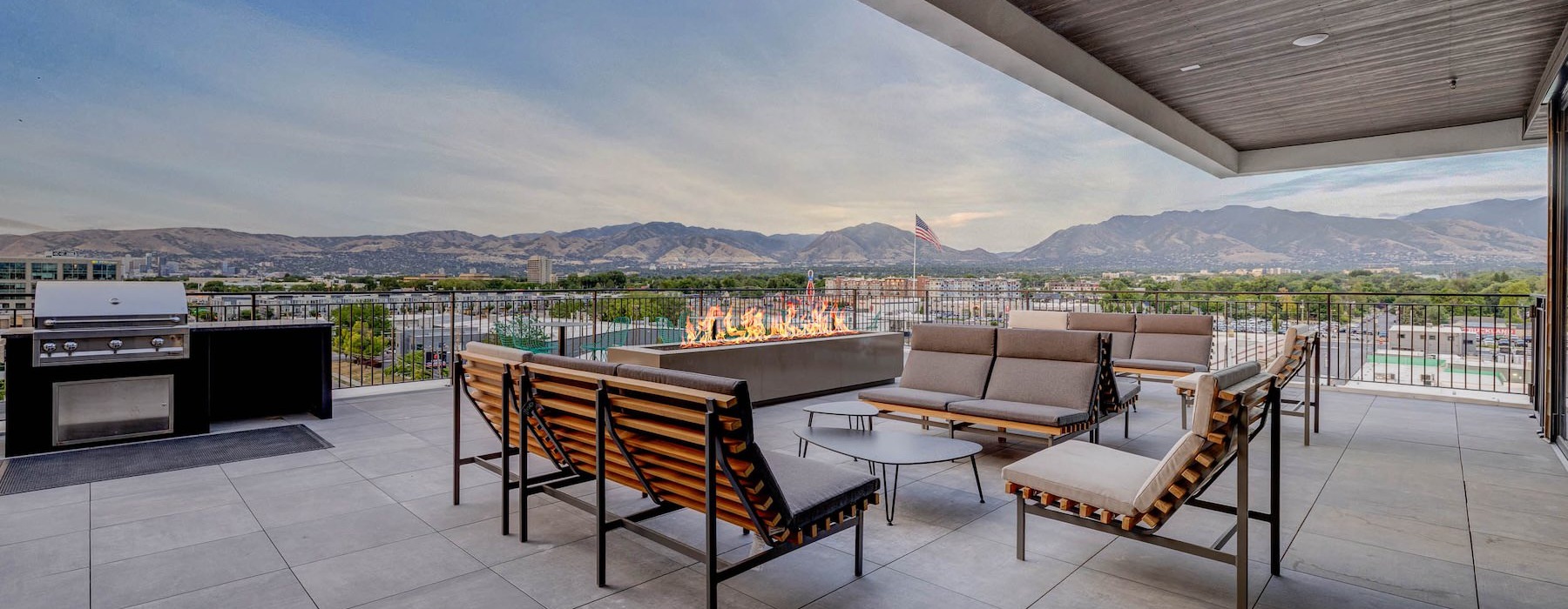 a patio with a grill, couches and a fireplace