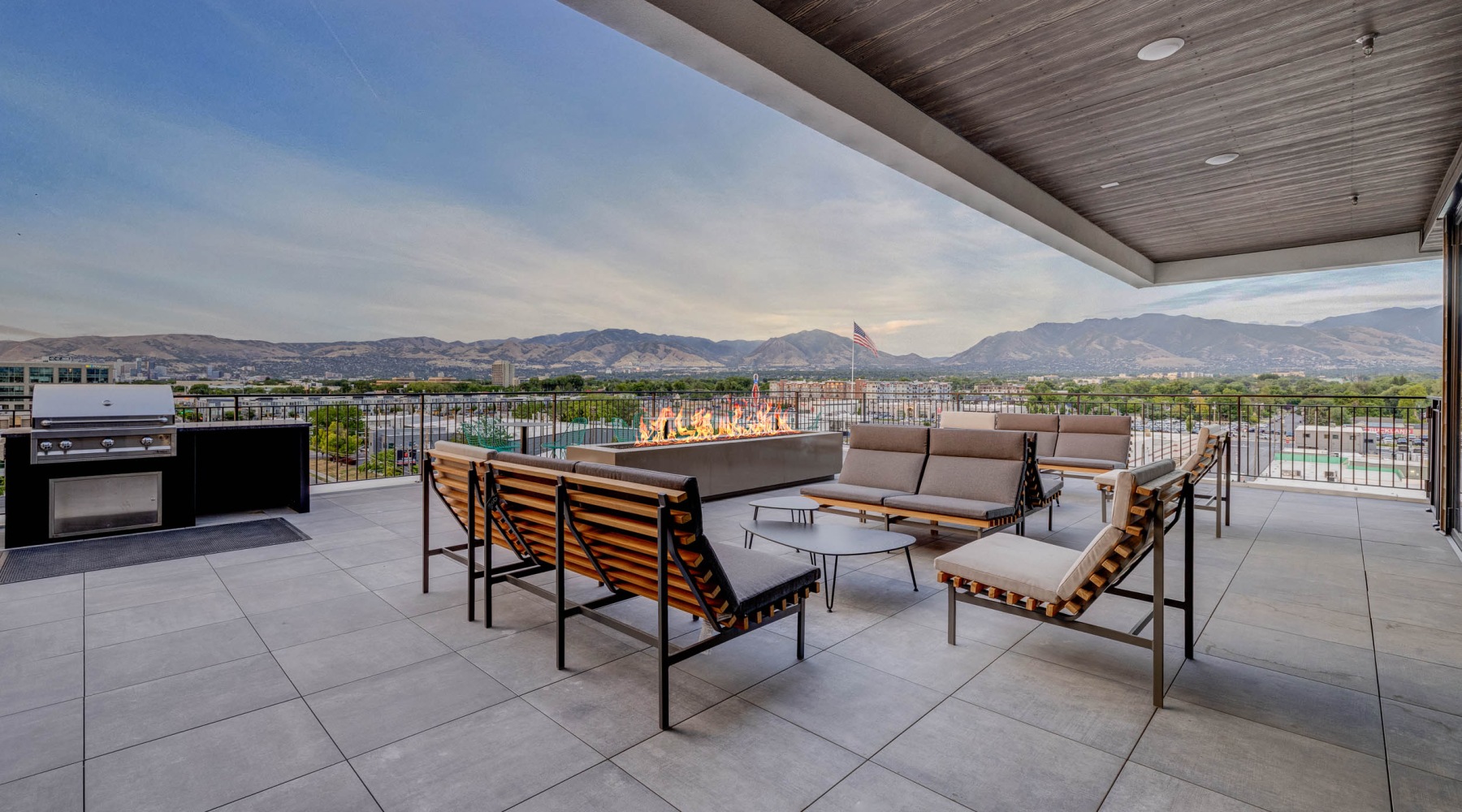 a patio with a grill, couches and a fireplace